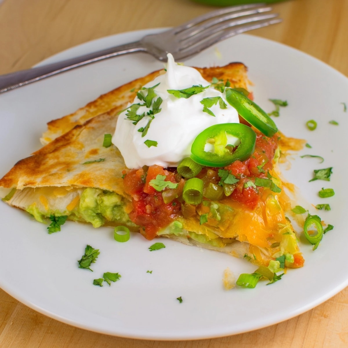 Close-up of a warm, crispy Avocado Cheddar Grilled Quesadilla with fresh cilantro.