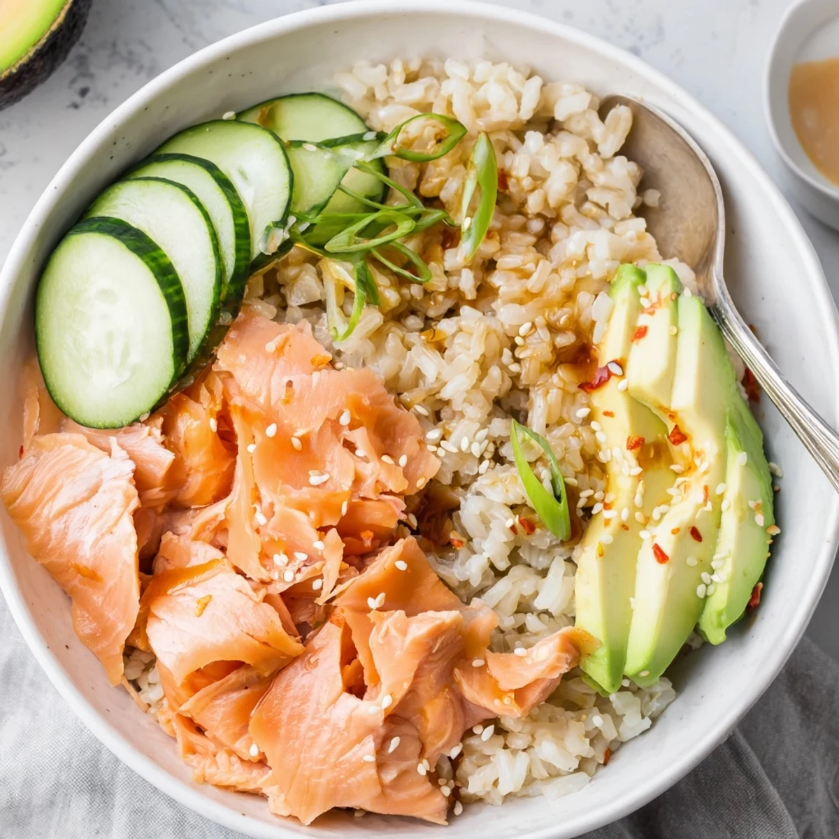 Delicious Leftover Salmon & Rice Bowl topped with fresh avocado and cucumber slices.  
