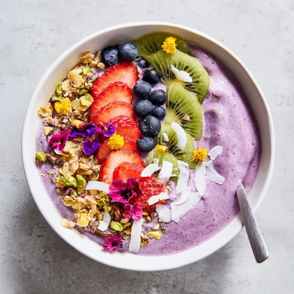 Fresh fruit and crunchy toppings decorate these vibrant smoothie bowls for a tasty morning treat.  