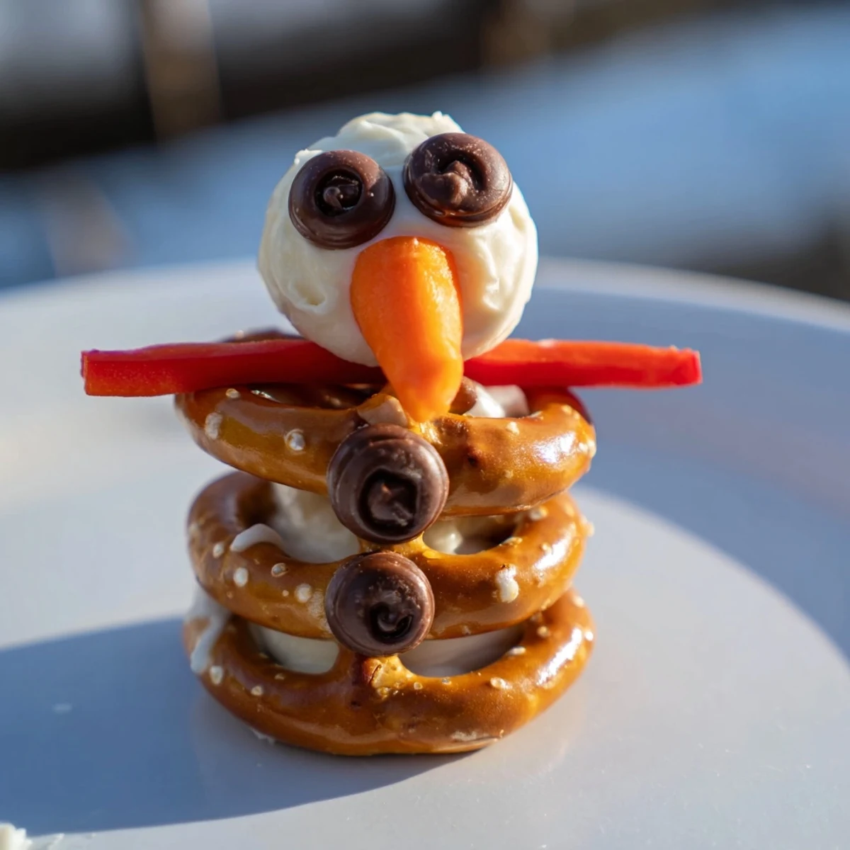 Delicious snowman pretzel and dip platter, featuring smiling pretzel snowmen with colorful scarf details.