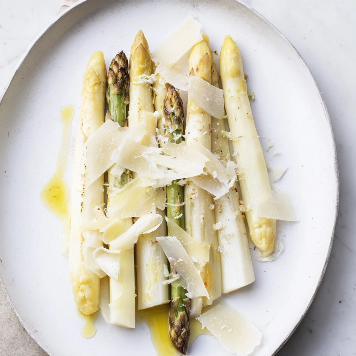 Elegant The Silver Birch starter: tender white asparagus, creamy cheese, and black truffle shaving's aromatic essence.