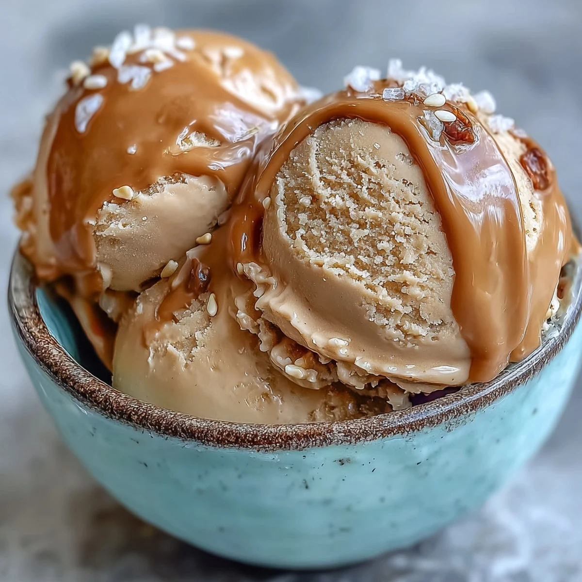 Scoops of creamy Hojicha Ice Cream in a bowl with toasted sesame seeds, showcasing its rich, roasted aroma.