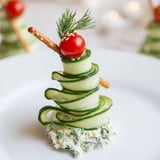 Spiral cucumber ribbon Christmas trees appetizer: Crisp cucumber ribbons with creamy cheese, a festive holiday treat.