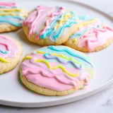 Buttery, golden sugar cookies are topped with a sweet, vibrant icing drizzle for dessert.