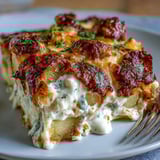 Creamy Ranch Chicken Potato Bake features bubbling cheddar and mozzarella over tender chicken and golden potatoes, fresh chives garnish.