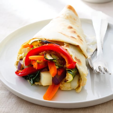 Snowflake Hummus & Roasted Veggie Wrap, showcasing colorful, tender roasted vegetables wrapped in a tortilla.