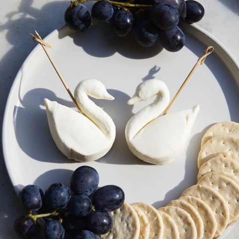 Elegant Swan Lake Board with cheese swans and vibrant blue grapes for a stunning appetizer.