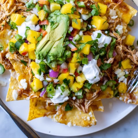 Close-up of Mango Pineapple Chicken Nachos, a festive appetizer ready to be served.