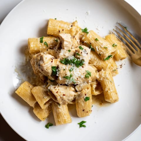 Creamy Garlic Butter Chicken with Rigatoni and Parmesan, garnished with fresh parsley.  
