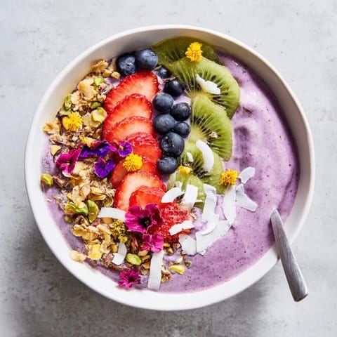 Fresh fruit and crunchy toppings decorate these vibrant smoothie bowls for a tasty morning treat.  